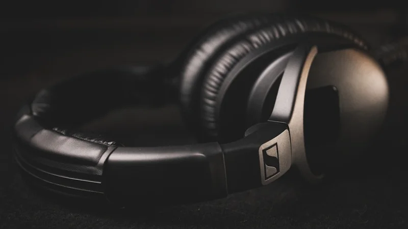 Sennheiser Momentum 4 Wireless headphones beside hi-fi setup with warm ambient light, audiophile aesthetic