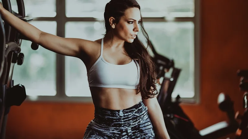 Adjustable dumbbells and resistance bands on a home gym floor with natural light