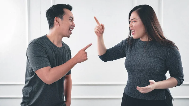 A close-up of two hands reaching across a wooden table toward each other in warm, even light — representing the stakes of productive conflict in relationships that matter