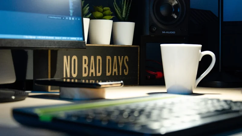 Minimalist flat-lay of a tidy workspace with a small notepad pen and coffee cup
