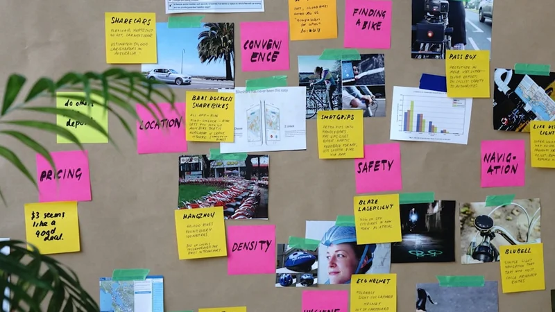 Close-up of hands pinning a specific goal image onto a vision board with written targets visible