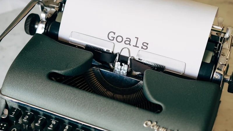 clean desk with single notebook and single clear goal written on it, representing committed satisficing strategy