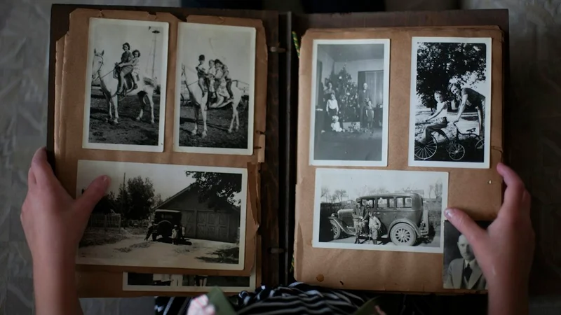 Open journal on a wooden desk with a pen resting inside, a small photograph tucked into the cover