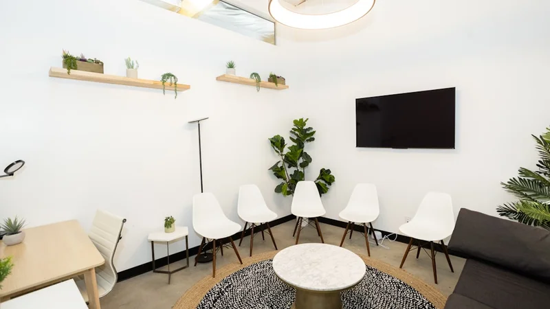 A person sitting at a well-organized, intentionally designed workspace with minimal distractions and a clear desk setup