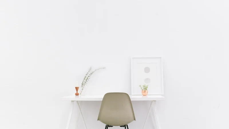 Minimalist workspace with a single notebook, pen, and laptop — clean and uncluttered — habits blocking personal growth being removed | habits blocking personal growth minimalist workspace