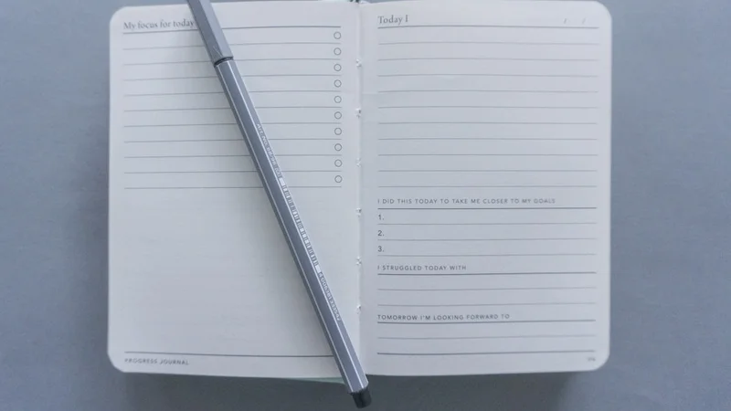 open journal with handwritten notes and a warm cup of tea on a wooden desk in morning light, representing intentional self-reflection on social connection patterns and belonging as a daily practice