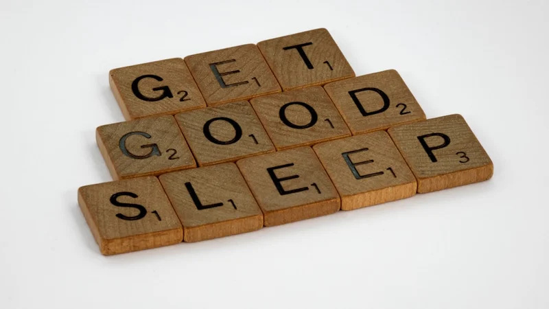 person sleeping soundly in a dark, organized bedroom with a sleep tracker visible on the nightstand