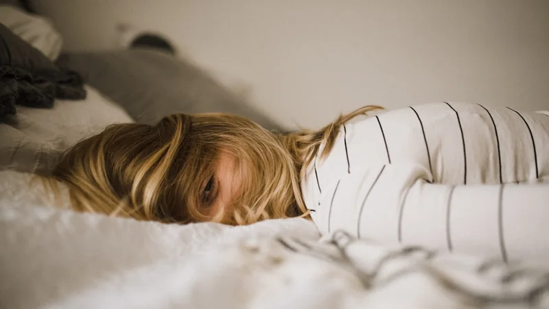 Person standing in morning golden sunlight within 30 minutes of waking, no phone, holding coffee, outdoors or near open window, calm purposeful expression