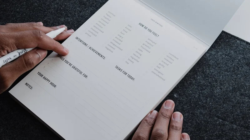 An open minimalist journal with a handwritten "Stop Doing List" header and three crossed-out items on an uncluttered desk