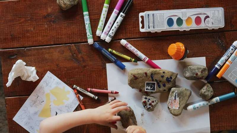 young child building freely with colorful open-ended wooden blocks, warm natural light, no instruction manual in sight